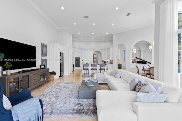 living room with crown molding and a high ceiling