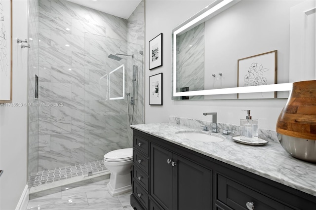 bathroom with vanity, toilet, and tiled shower