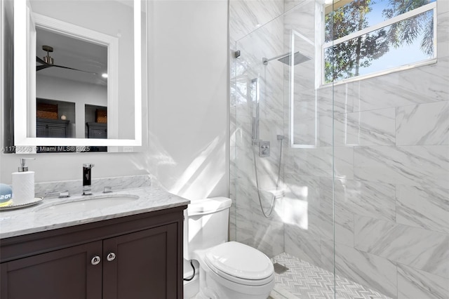 bathroom featuring vanity, a shower with shower door, and toilet