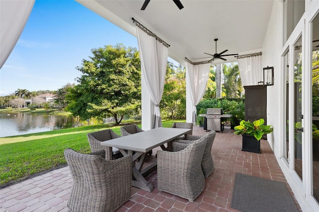 sunroom with a water view and ceiling fan