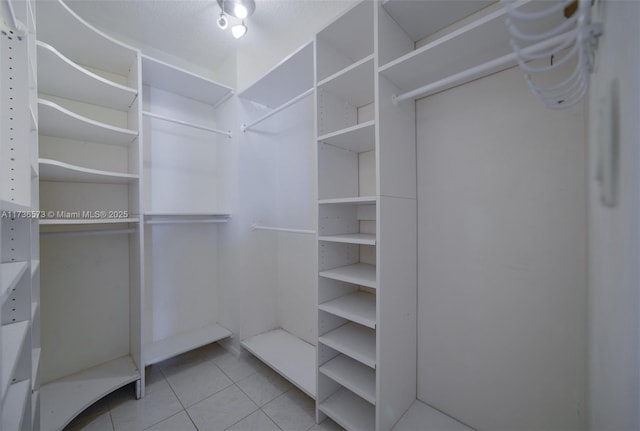 spacious closet with light tile patterned floors