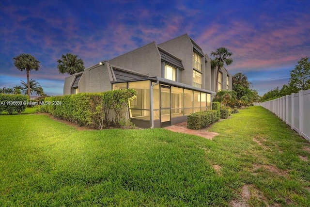 property exterior at dusk with a yard