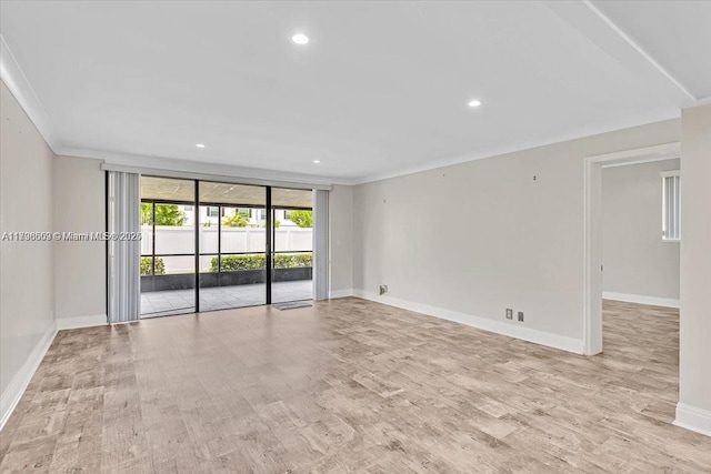 empty room featuring ornamental molding and light hardwood / wood-style flooring