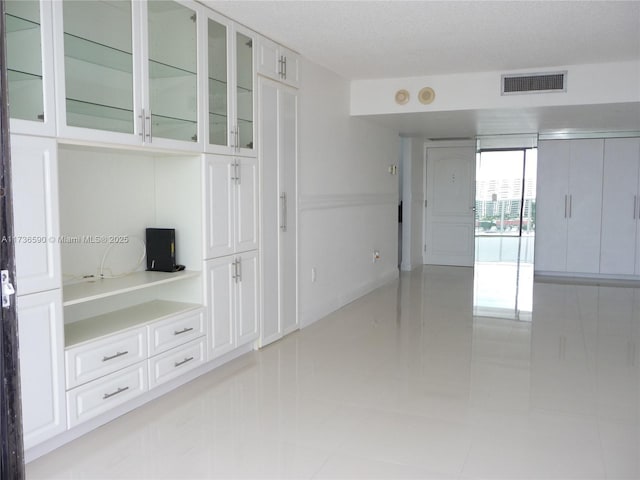 interior space with light tile patterned flooring and a textured ceiling