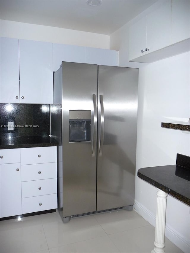 kitchen featuring white cabinetry, light tile patterned flooring, dark stone countertops, and stainless steel refrigerator with ice dispenser