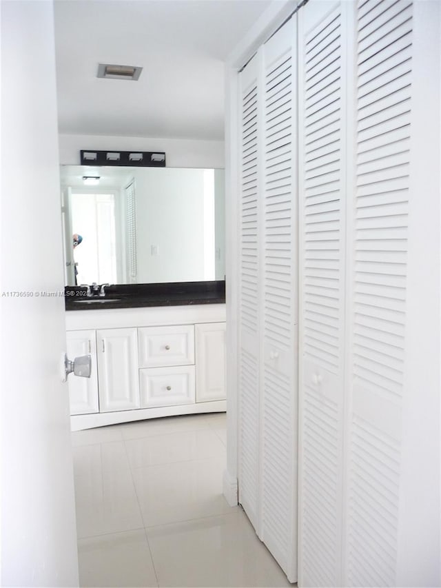 corridor featuring sink and light tile patterned floors