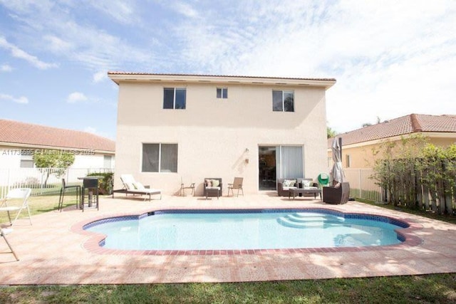 rear view of property with a fenced in pool, a patio area, and outdoor lounge area