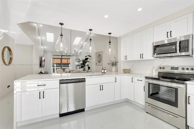 kitchen with stainless steel appliances, pendant lighting, white cabinets, and kitchen peninsula