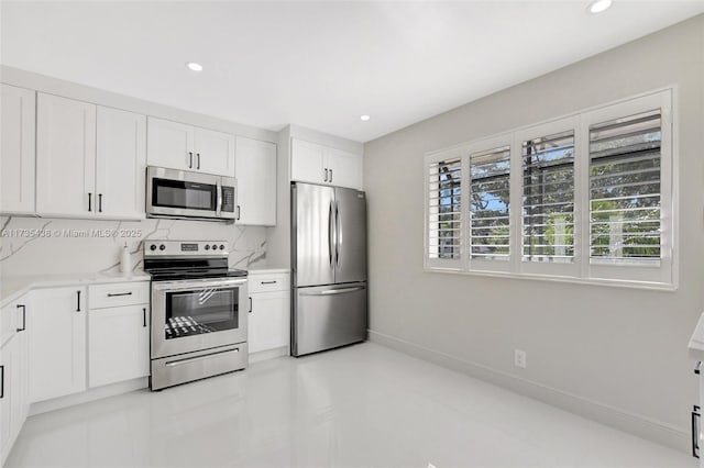 kitchen with stainless steel appliances, white cabinetry, a wealth of natural light, and decorative backsplash