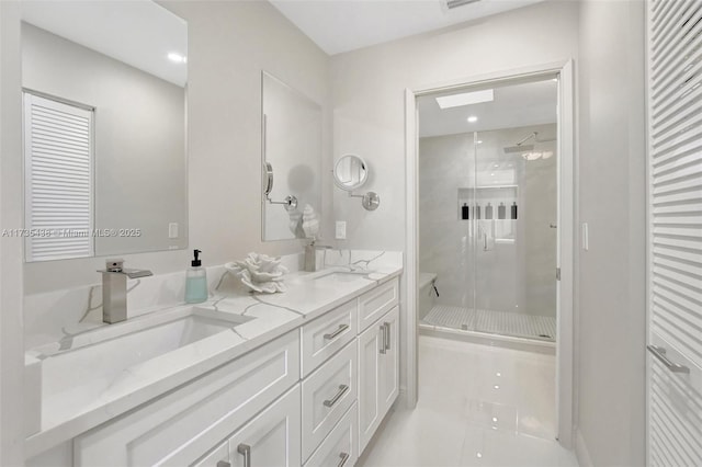 bathroom featuring vanity, a shower with shower door, and tile patterned flooring