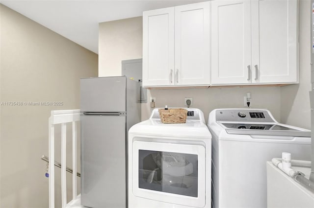 clothes washing area featuring cabinets and separate washer and dryer