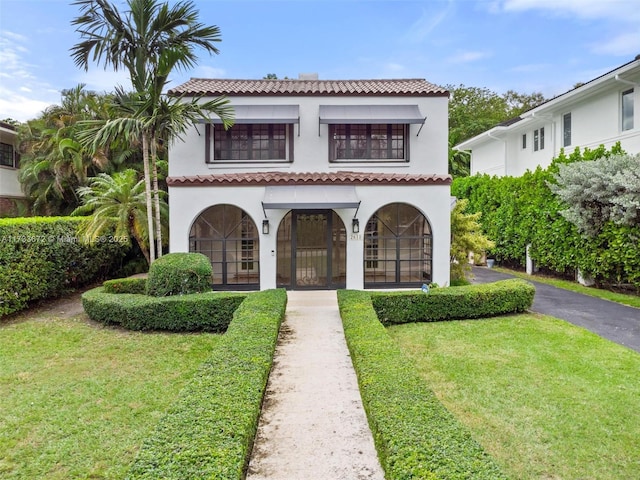 mediterranean / spanish home featuring french doors and a front lawn