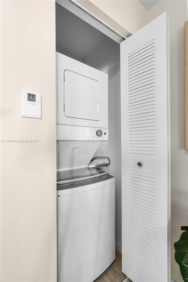 washroom featuring stacked washer and dryer and light hardwood / wood-style floors