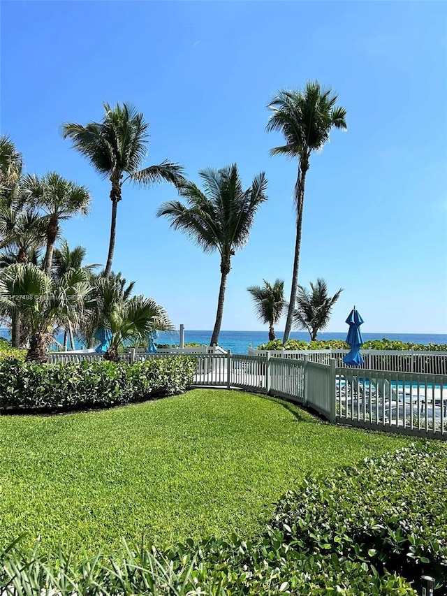 view of yard featuring a water view, fence, and a fenced in pool