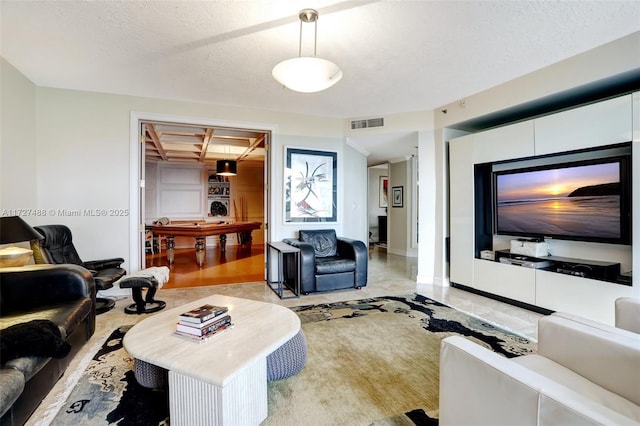 living area with a textured ceiling and visible vents