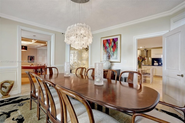 dining area featuring light tile patterned flooring, coffered ceiling, crown molding, and wainscoting