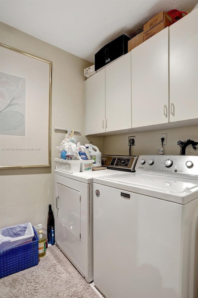 laundry area with cabinets, washing machine and dryer, and carpet