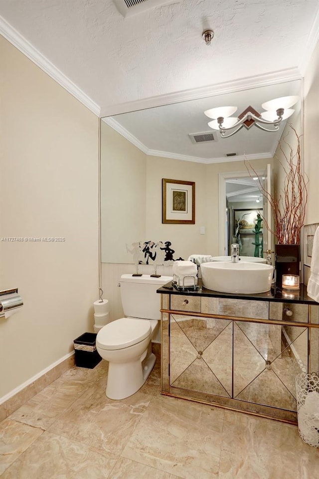 half bathroom with toilet, visible vents, baseboards, vanity, and crown molding