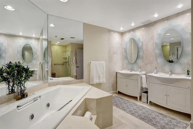 bathroom with tile patterned flooring, vanity, independent shower and bath, and tile walls