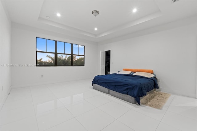 bedroom featuring a raised ceiling and light tile patterned floors