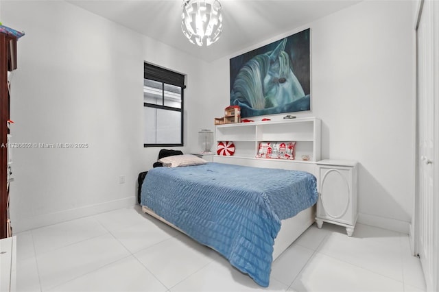 bedroom with light tile patterned floors and an inviting chandelier