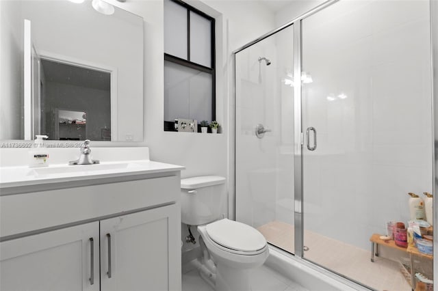 bathroom with a shower with door, vanity, and toilet