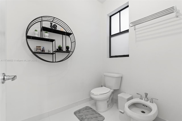 bathroom featuring a bidet, toilet, and tile patterned flooring