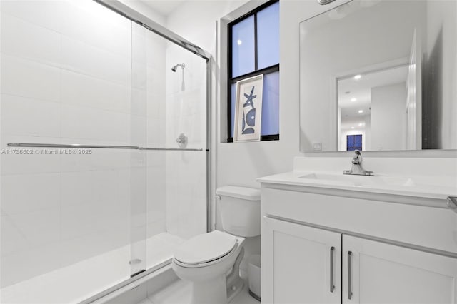 bathroom featuring vanity, an enclosed shower, and toilet