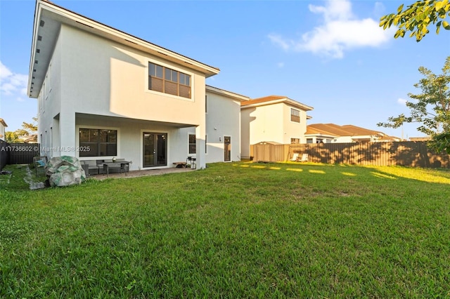 rear view of house featuring a yard