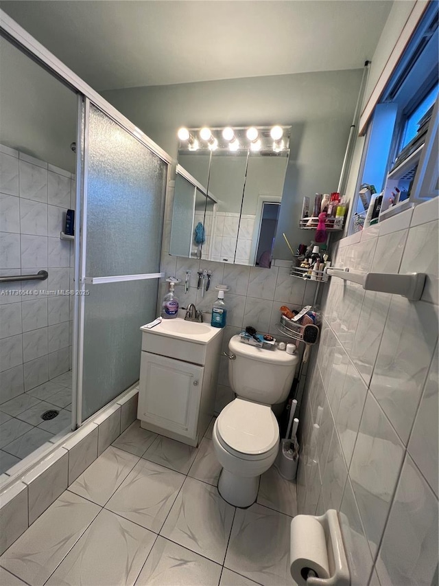 full bath with marble finish floor, tile walls, toilet, a shower stall, and vanity