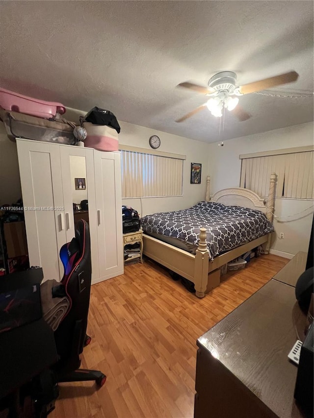 bedroom with a textured ceiling, light wood finished floors, and a ceiling fan