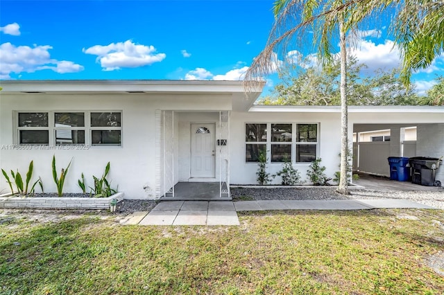 view of front facade featuring a carport and a front lawn