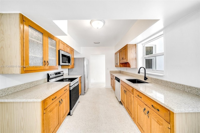 kitchen featuring sink, light stone countertops, and appliances with stainless steel finishes