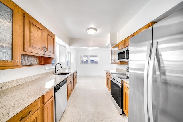 kitchen with sink, stainless steel appliances, and light stone countertops