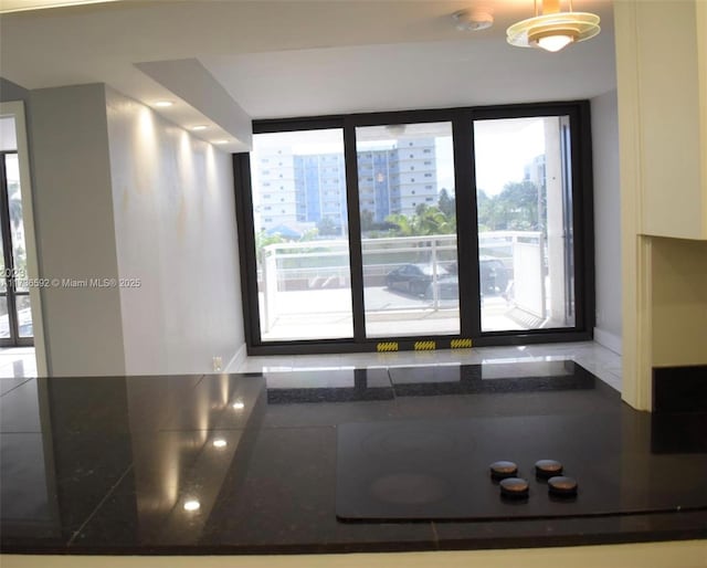 interior space featuring dark countertops, baseboards, and black electric cooktop