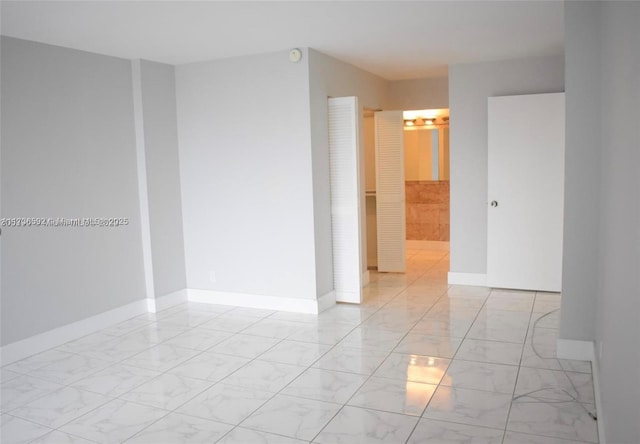 empty room with marble finish floor and baseboards