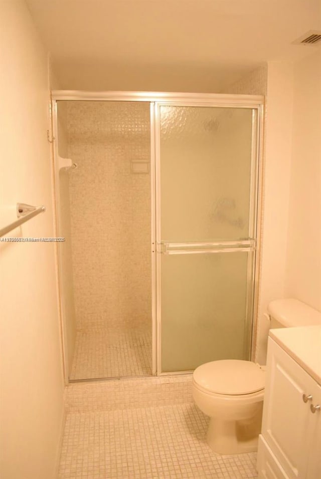 full bathroom featuring toilet, tile patterned flooring, vanity, and a shower stall