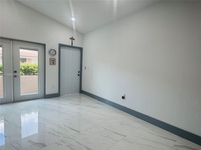 unfurnished room featuring lofted ceiling and french doors