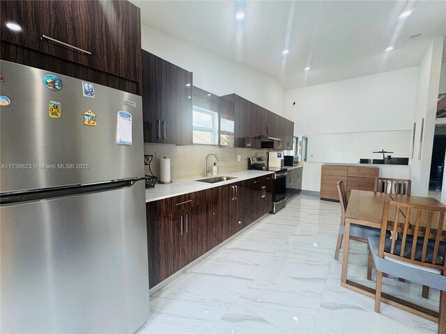 kitchen featuring french doors, sink, stainless steel range with electric cooktop, high vaulted ceiling, and decorative backsplash