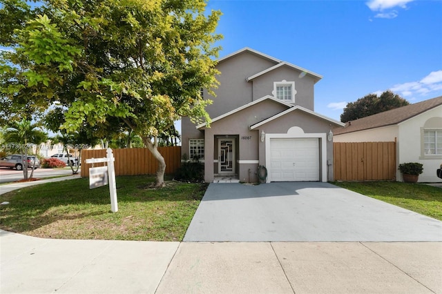 view of property featuring a garage and a front lawn