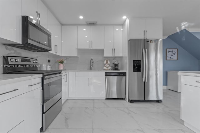 kitchen featuring appliances with stainless steel finishes, sink, white cabinets, and backsplash