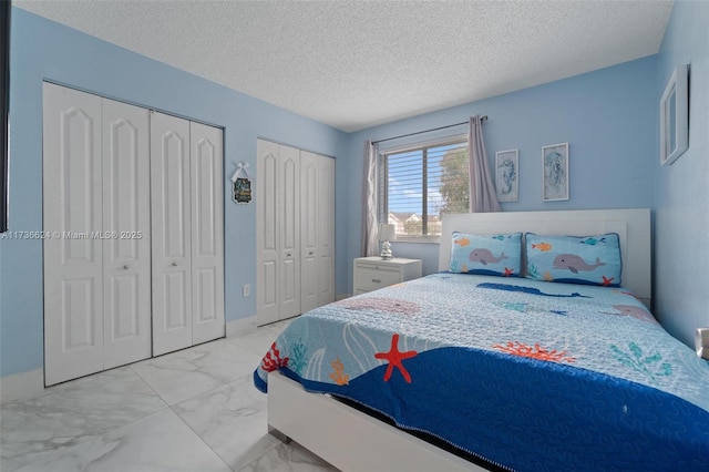 bedroom with multiple closets and a textured ceiling