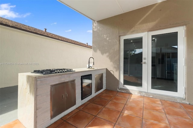 view of patio / terrace with french doors, an outdoor kitchen, and sink