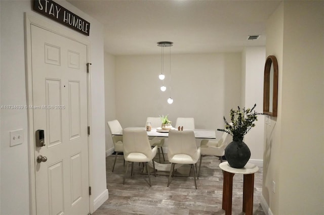 dining room with baseboards, wood finished floors, and visible vents
