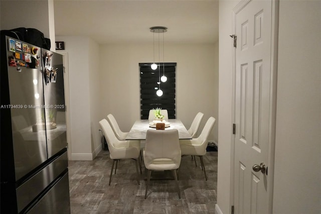 dining room with baseboards and wood finished floors