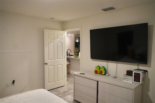 bedroom featuring sink and light wood-type flooring