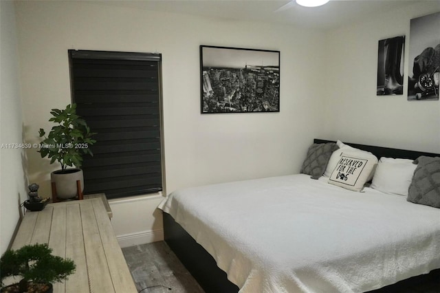 bedroom with baseboards and wood finished floors