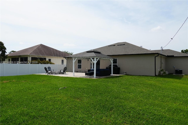 rear view of house with a gazebo, cooling unit, fence, a yard, and a patio