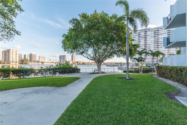 view of home's community with a water view and a yard