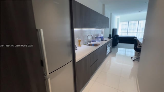 kitchen with sink, light tile patterned floors, and stainless steel fridge